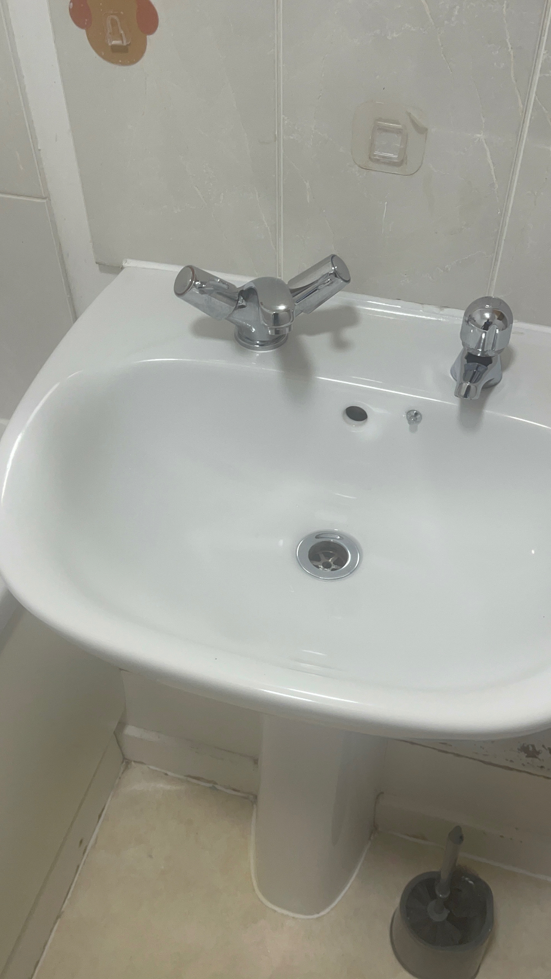 Bathroom basin, chrome taps and surrounding tiles — after cleaning
